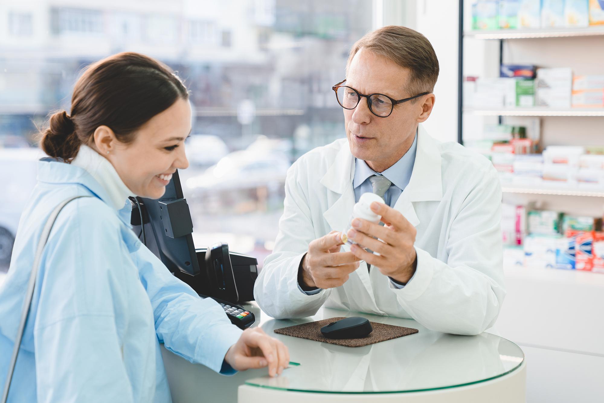 A pharmacist talking to his client about her new medicine